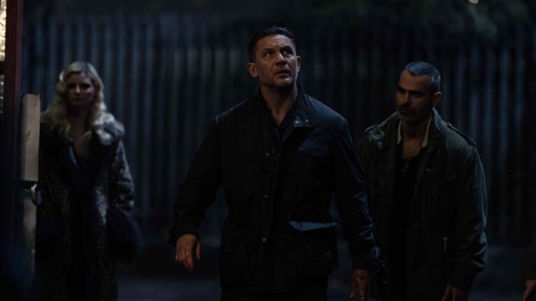 Trois personnes regardent vers le haut dans l'obscurité.