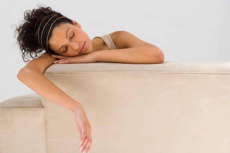 Personne dormant sur un canapé beige.