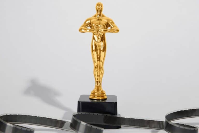 Statuette en or sur socle noir, pellicule en avant-plan.