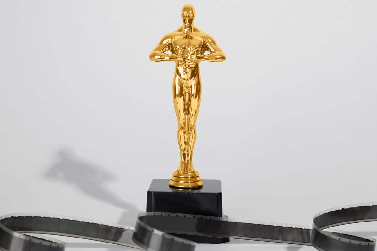 Statuette en or sur socle noir, pellicule en avant-plan.