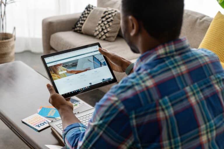 Homme utilisant une tablette dans un salon moderne.