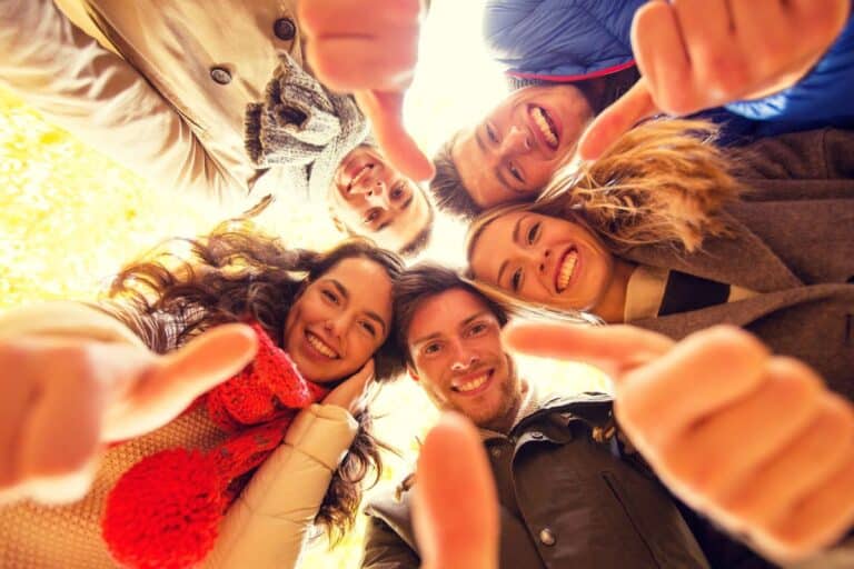Groupe de personnes souriant avec pouces levés.