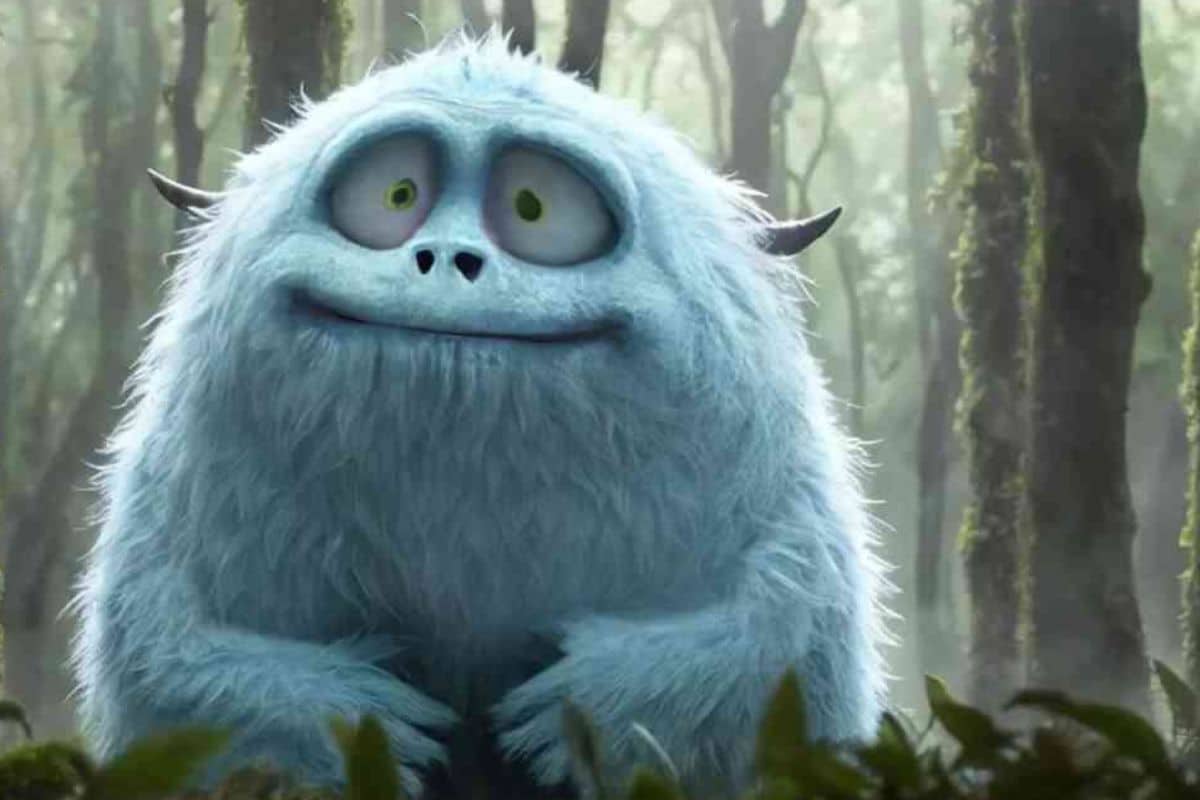 Créature blanche souriante dans une forêt verdoyante.