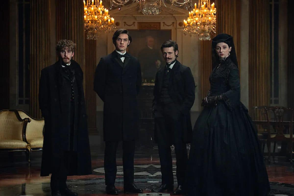 Quatre personnes en costumes victoriens dans un salon.