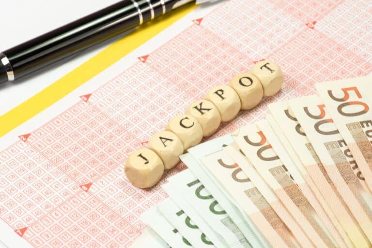 Billets euros, jackpot, grille de loto, stylo.