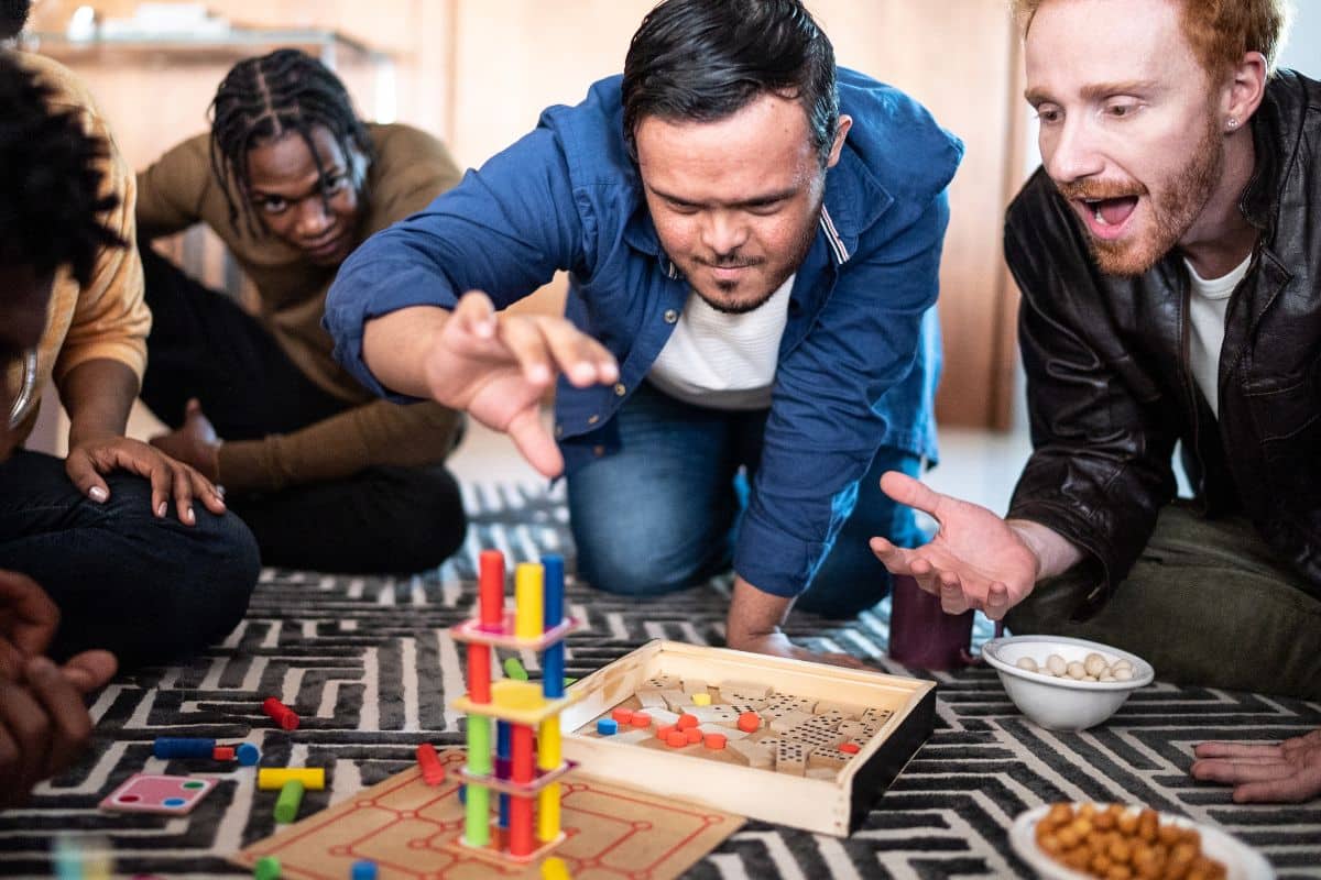 Personnes jouent à un jeu de société sur le sol.