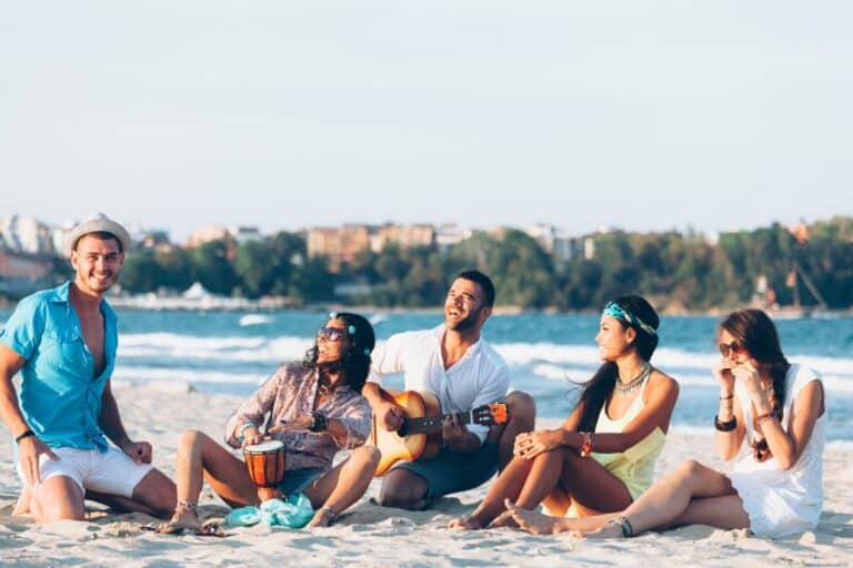 Groupe d'amis jouant de la musique sur la plage.