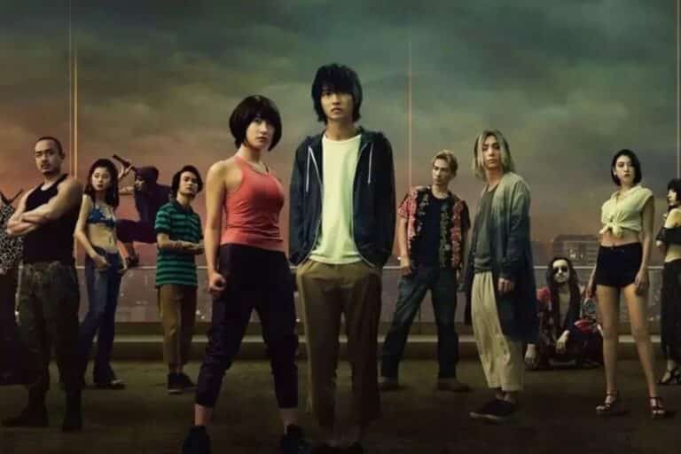 Groupe de personnes posant devant un ciel sombre.