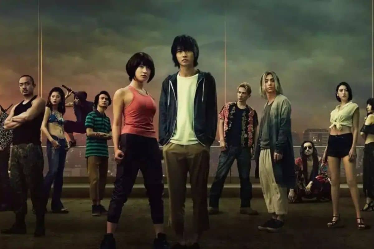 Groupe de personnes posant devant un ciel sombre.