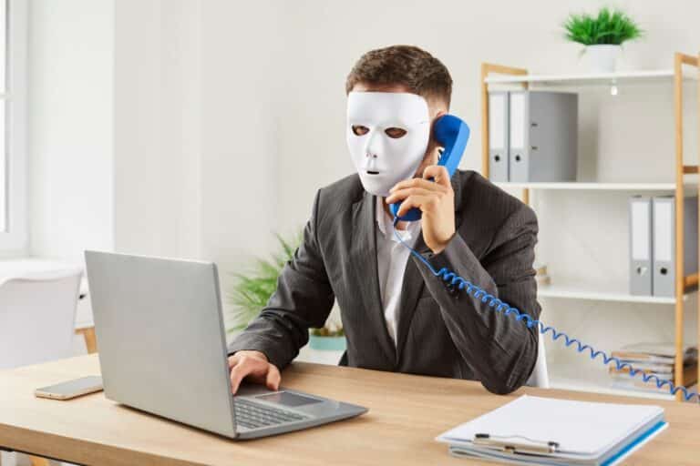 Homme masqué téléphone au bureau.