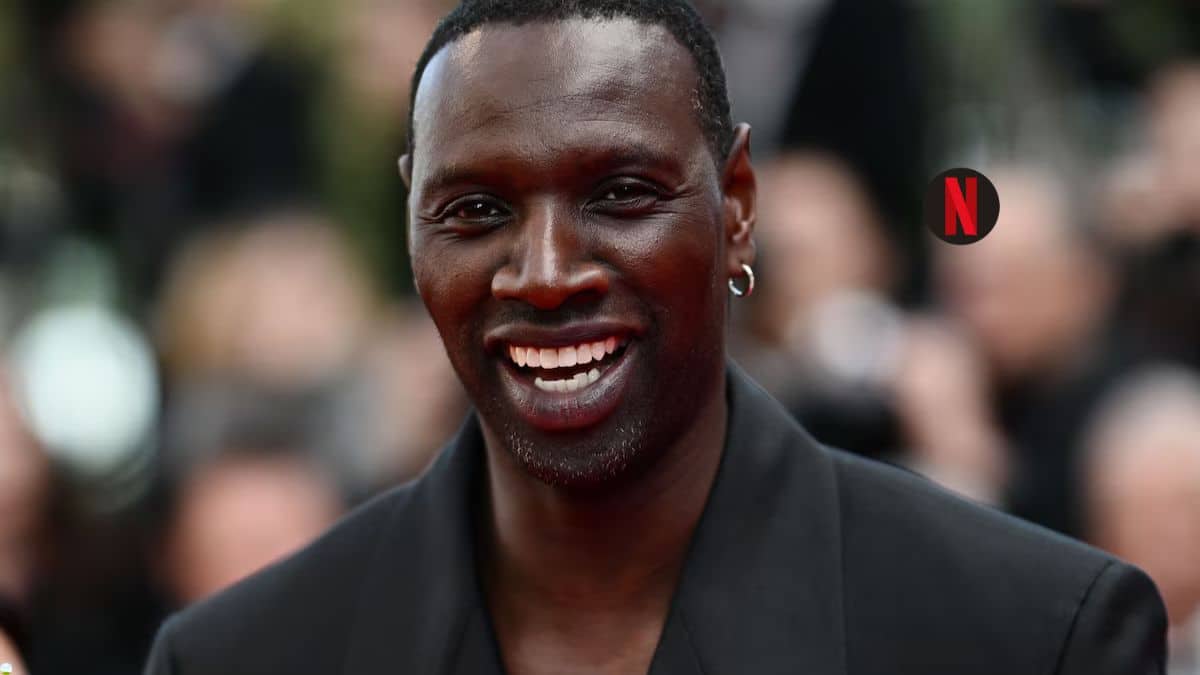 Personne souriante avec boucle d'oreille, arrière flou.