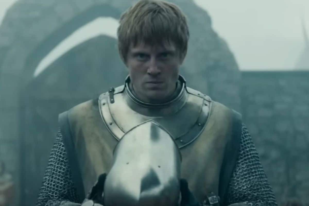 Chevalier en armure tenant un casque.