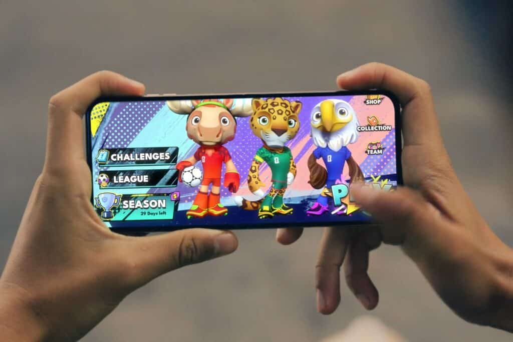 Personne jouant jeu mobile avec animaux sportifs.