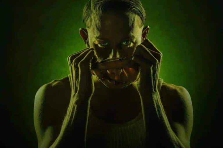 Homme retirant masque visage, ambiance sombre.