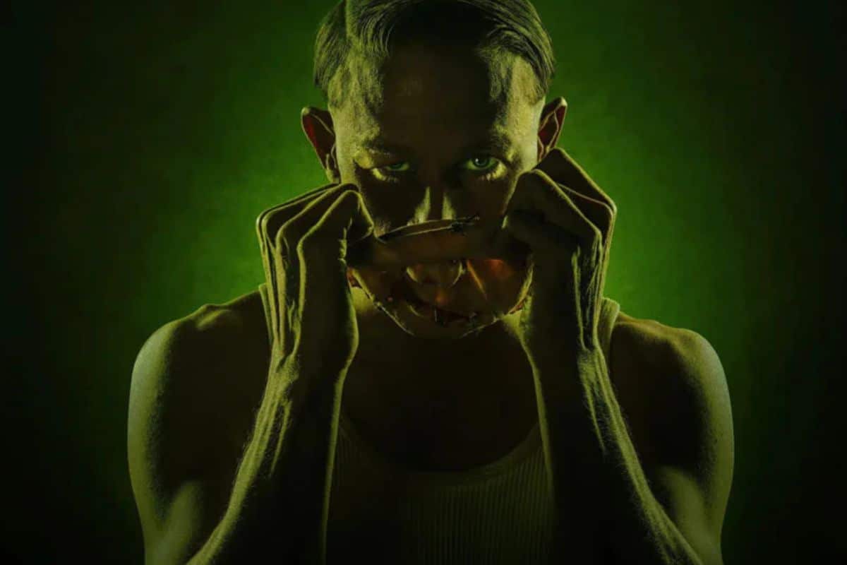 Homme retirant masque visage, ambiance sombre.