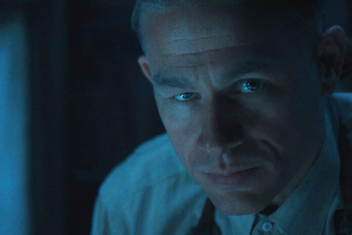 Homme en chemise dans une lumière bleutée.