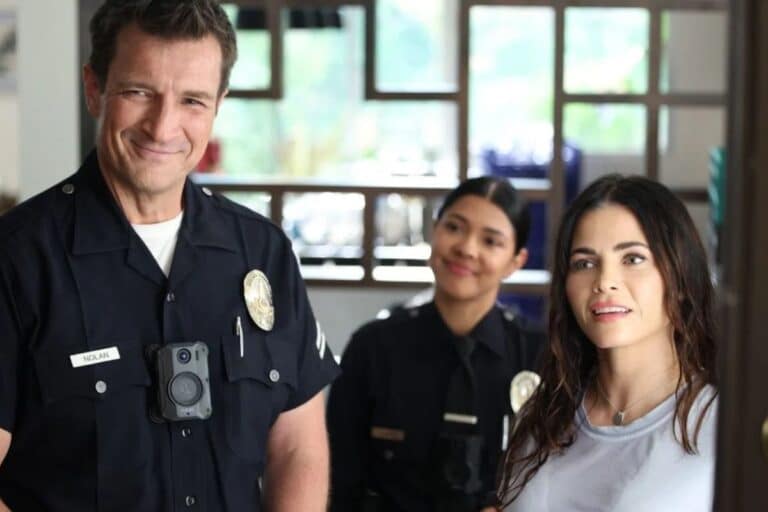 Deux policiers et une femme discutent souriants.