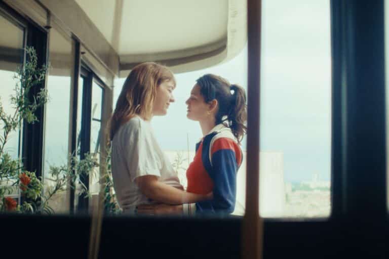 Deux personnes s'embrassant sur un balcon.