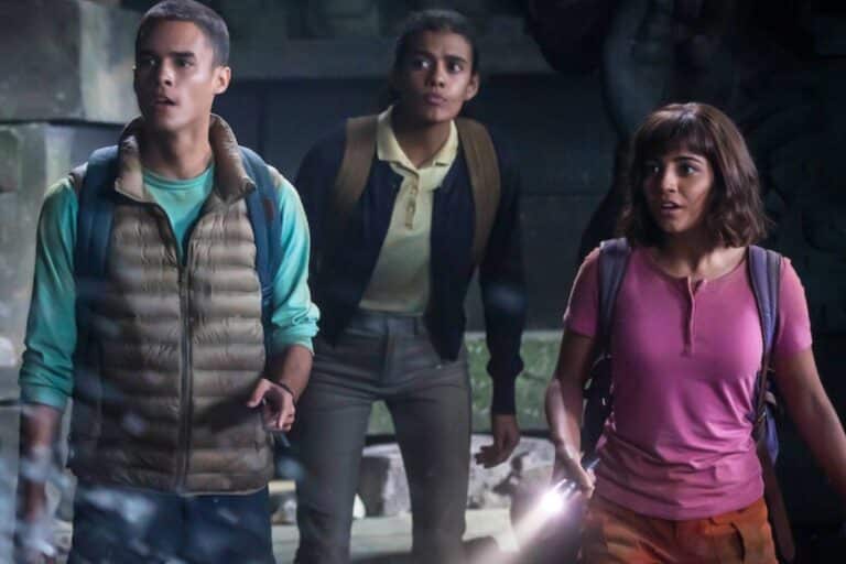 Trois jeunes explorent une grotte avec une lampe.