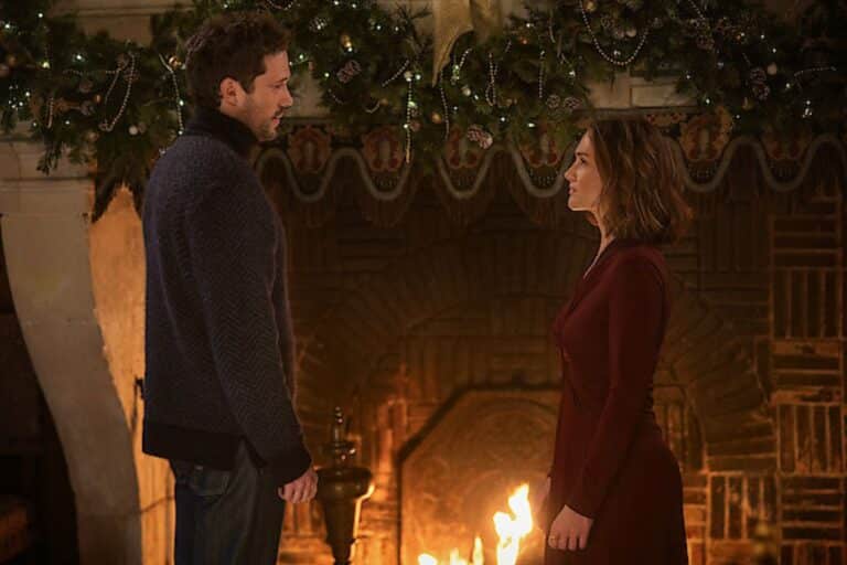 Deux personnes debout devant une cheminée décorée.