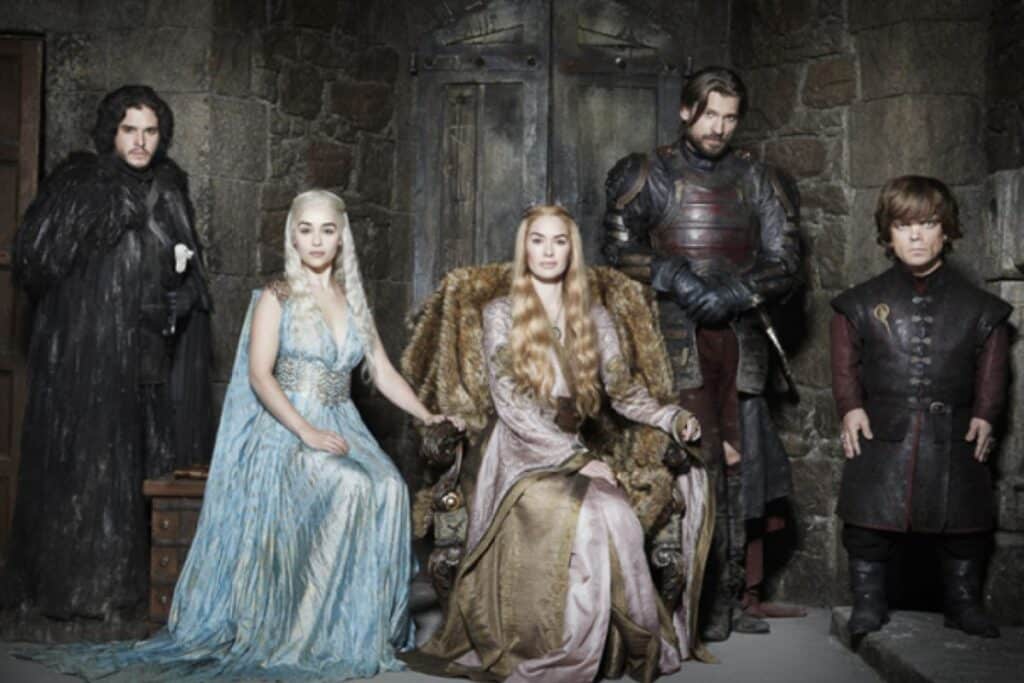 Cinq personnages en tenues médiévales dans une salle.