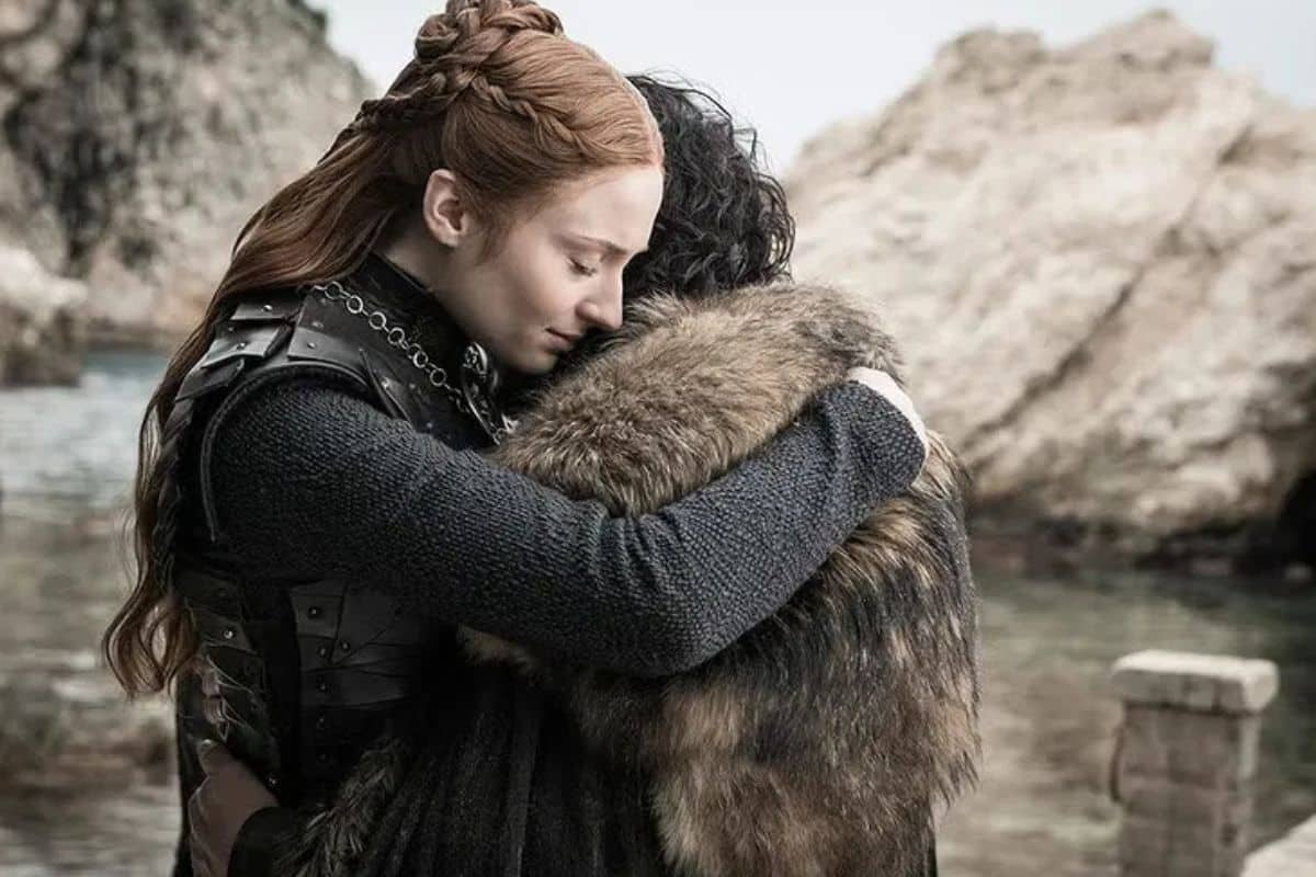 Deux personnages s'enlaçant devant un paysage rocheux.