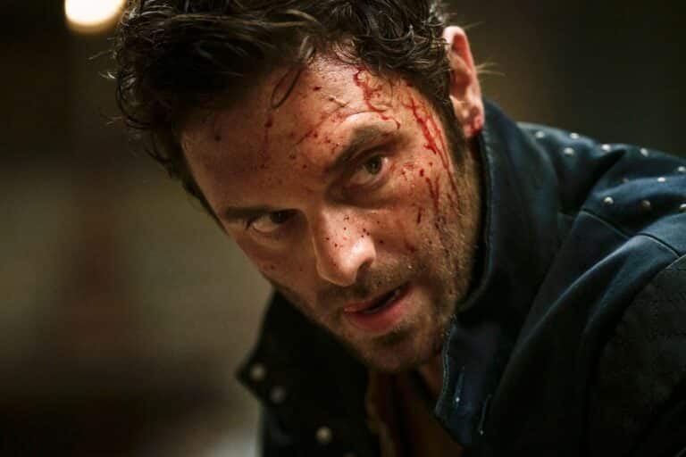 Homme blessé avec des éclaboussures de sang sur le visage.