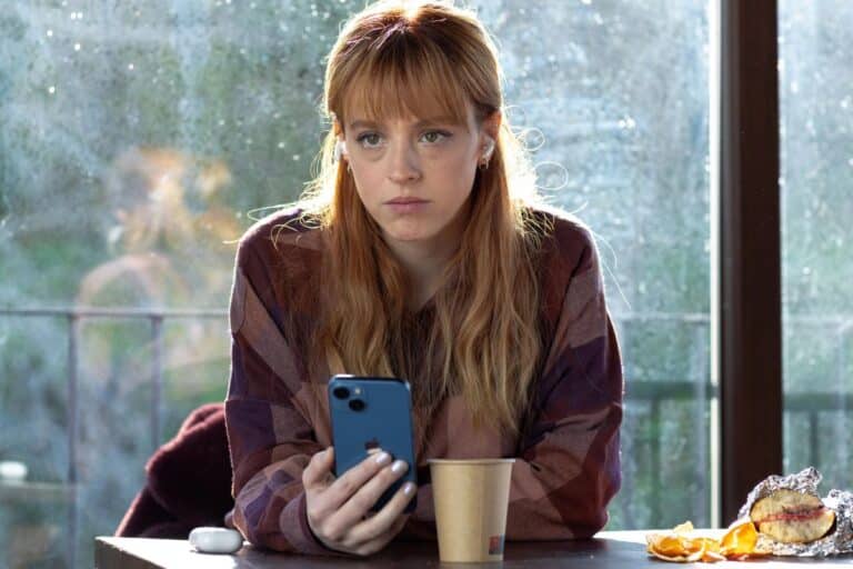 Femme regardant son smartphone avec air concentré.