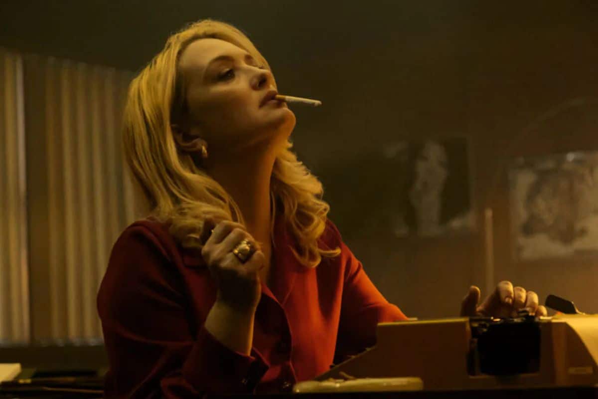 Femme blonde avec cigarette et machine à écrire.