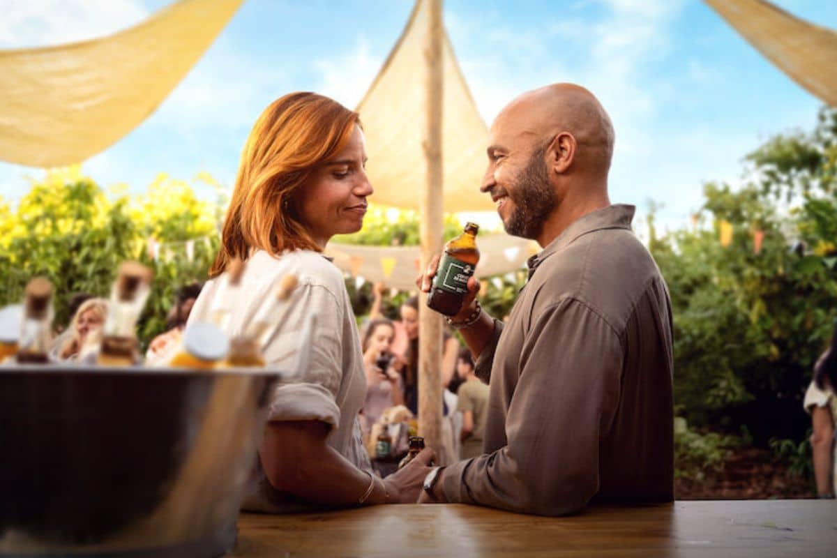 Deux personnes trinquent en extérieur, ambiance estivale.