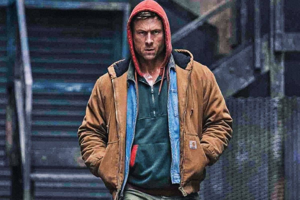 Personne avec veste brune et capuche rouge.