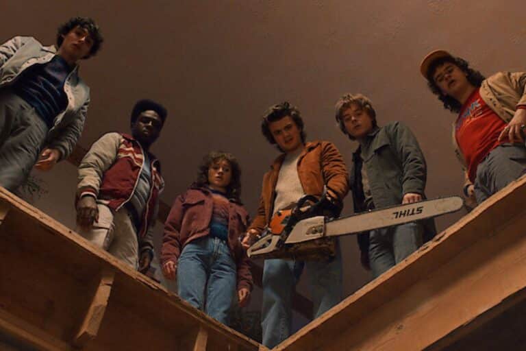 Groupe de jeunes regardant vers le bas avec tronçonneuse.