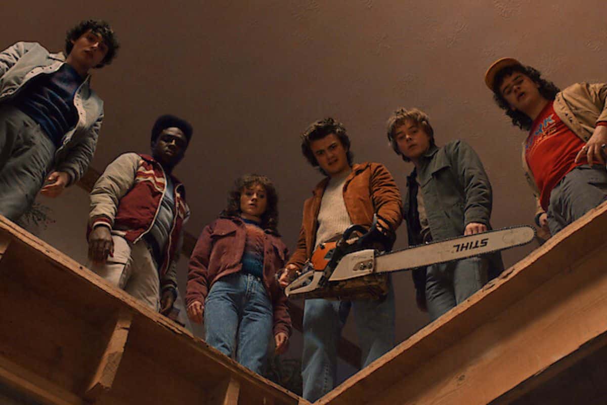 Groupe de jeunes regardant vers le bas avec tronçonneuse.