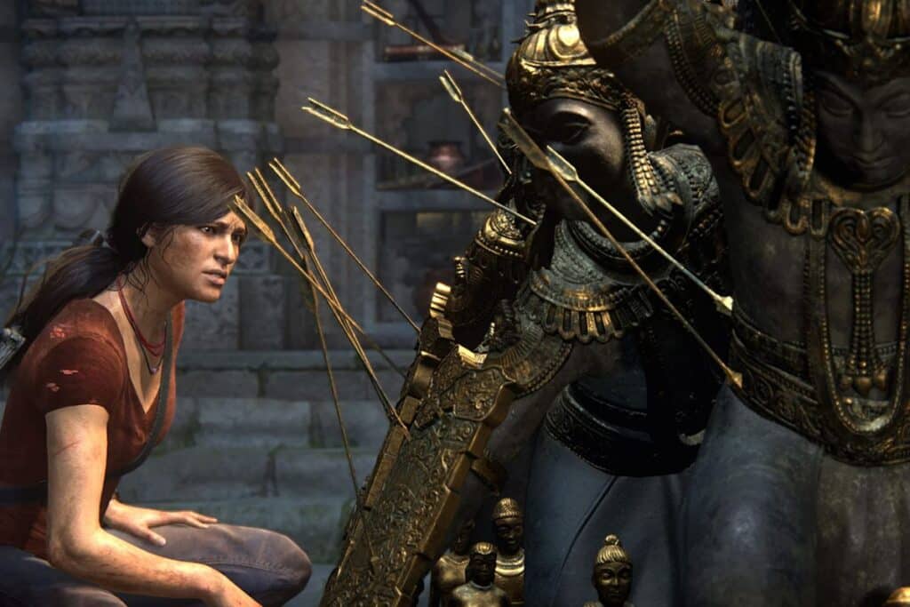 Femme devant statue indienne décorée avec flèches dorées.