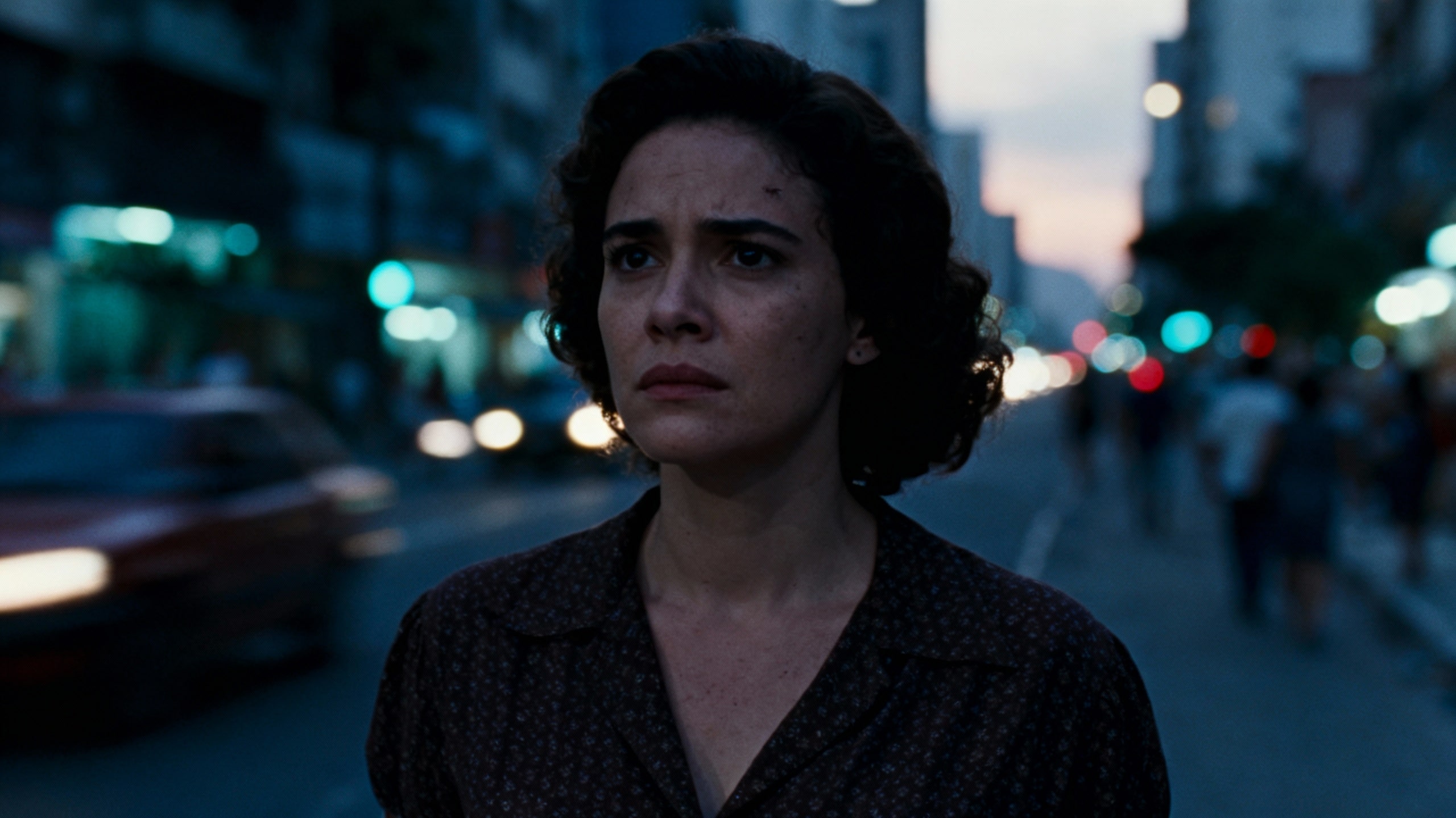 Personne pensive marchant dans une rue éclairée, crépuscule.