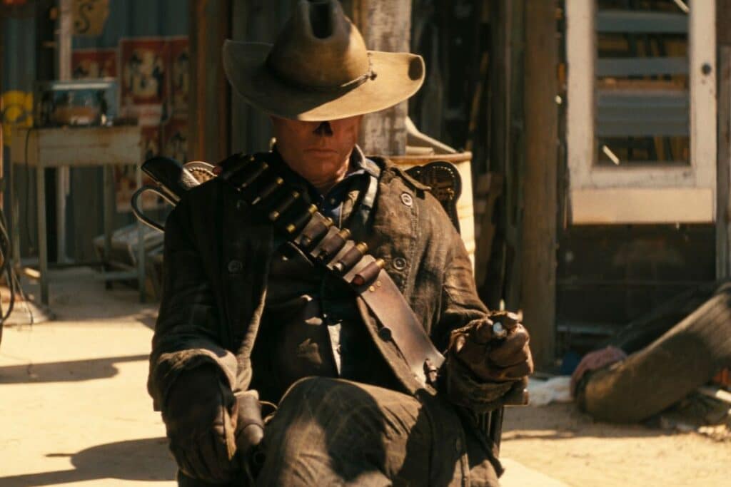 Cowboy assis avec chapeau et armes, ambiance western.