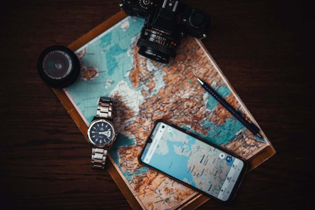 Carte, appareil photo, montre, smartphone et stylo.