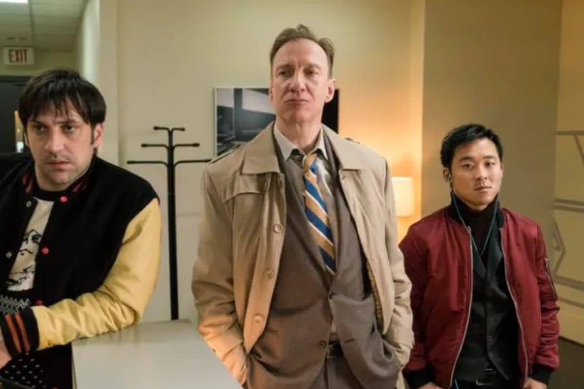 Trois hommes dans un bureau.