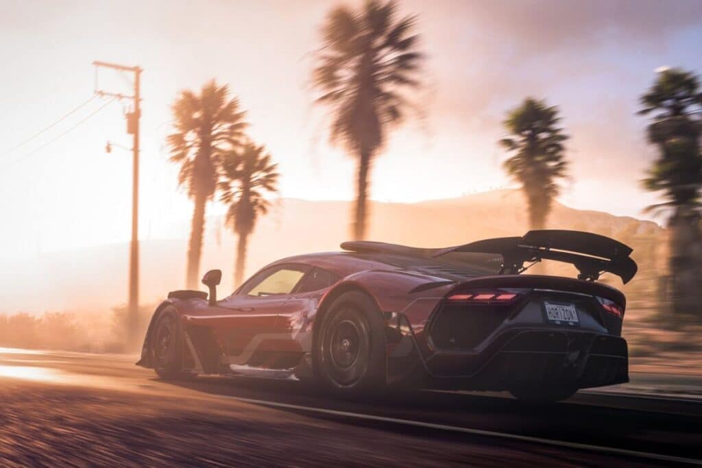 Voiture sportive au coucher du soleil, palmiers en arrière-plan.