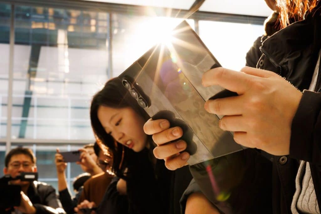 Personnes utilisant un smartphone pliable en plein soleil.