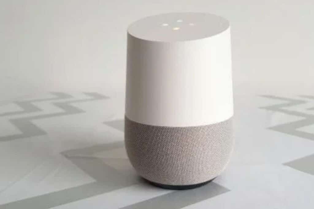 Enceinte intelligente blanche sur table grise.