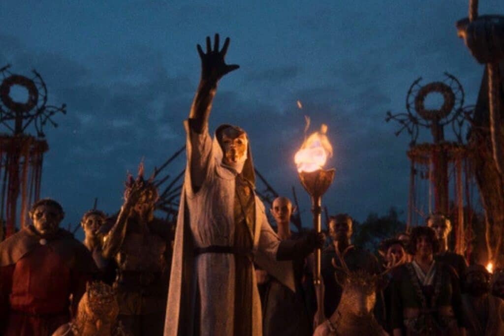 Personne masquée levant la main avec une torche.