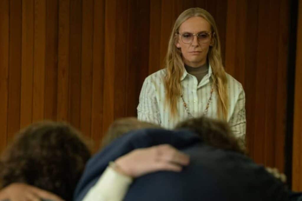 Femme sérieuse, regardant deux personnes s'enlaçant.