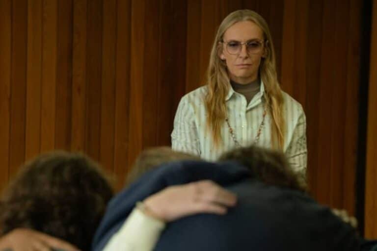 Femme sérieuse, regardant deux personnes s'enlaçant.