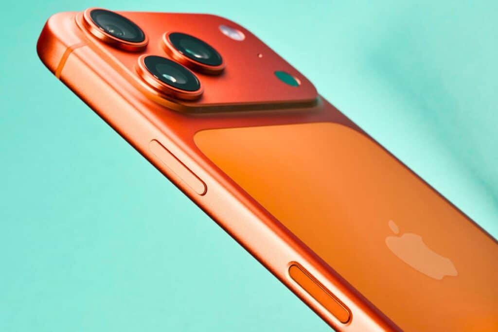 Smartphone orange avec trois caméras.