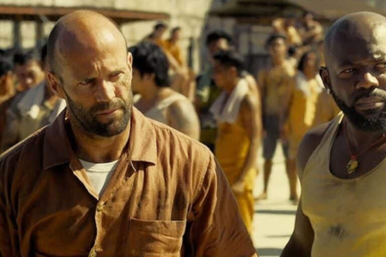 Deux hommes marchant dans une cour de prison.