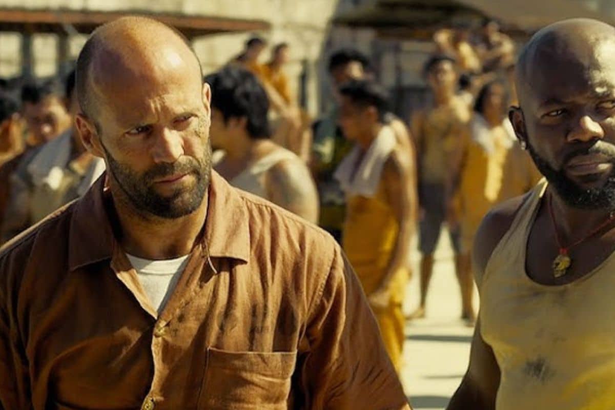 Deux hommes marchant dans une cour de prison.