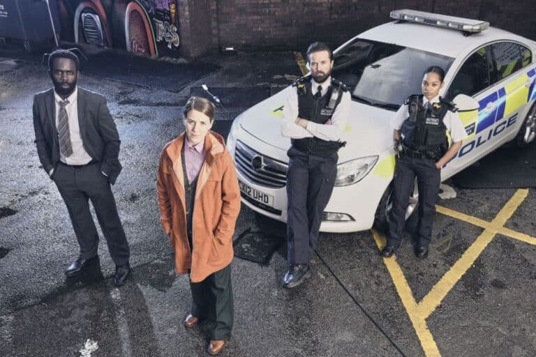 Équipe de policiers devant une voiture de police.