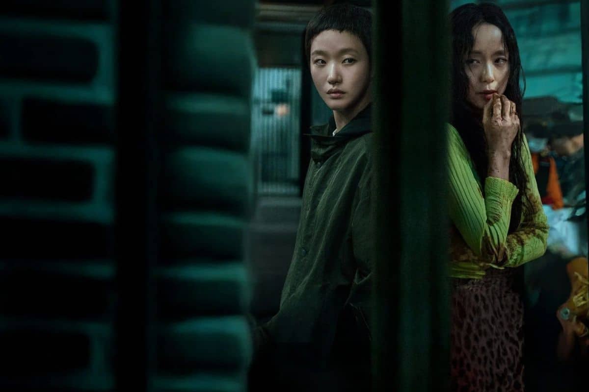 Deux personnes dans une ruelle sombre, expression pensive.