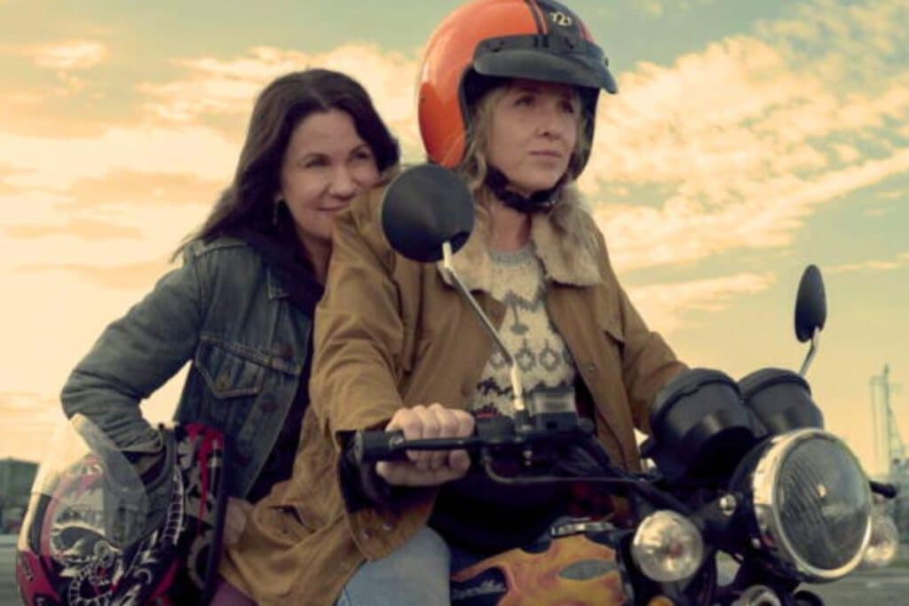 Deux femmes sur une moto au coucher du soleil.